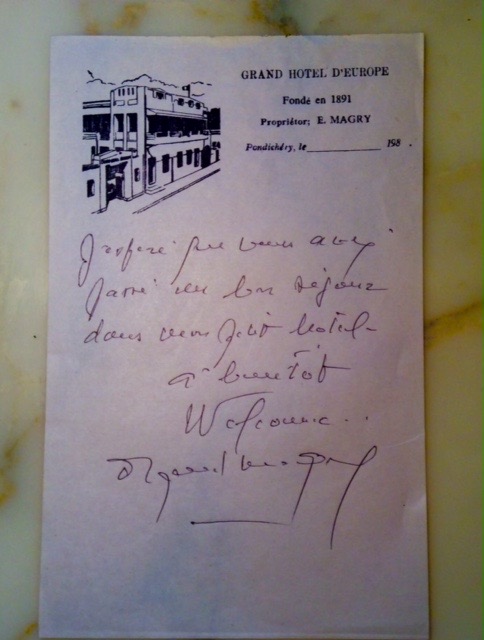 A handwritten note on illustrated hotel stationery