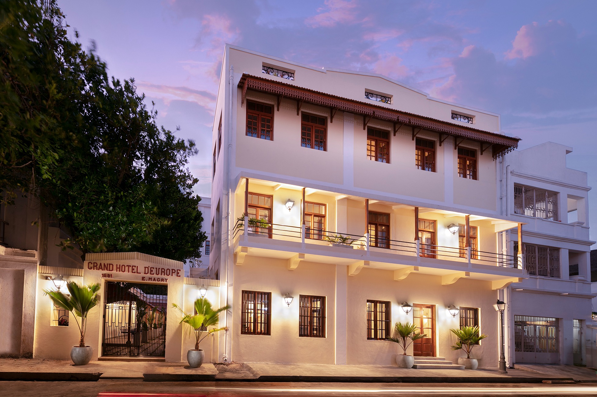 Grand Hotel D’Europe facade with timber windows, balconies and illuminated entrance, photographed at dusk